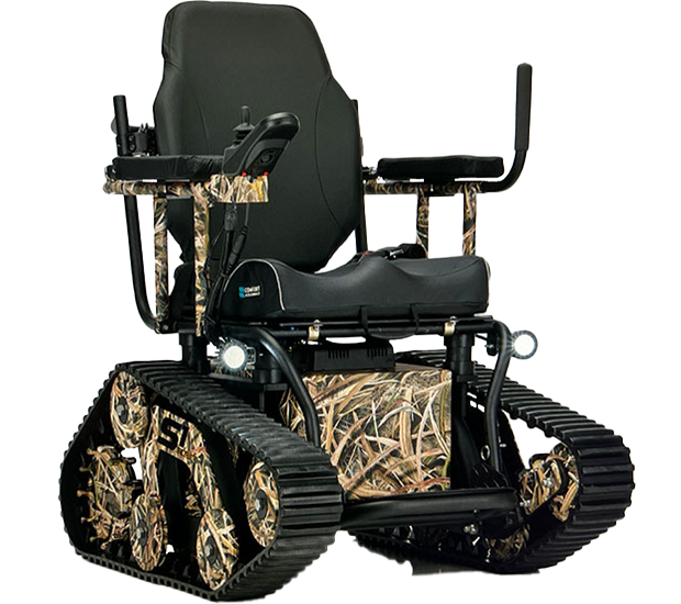 The TrackMaster Series 1 tracked power wheelchair featuring a camouflage-patterned chassis and bogie wheels. It has heavy-duty black tank treads, bright LED headlights, and a black contoured seat with a joystick controller, designed to fit through standard doorways while maintaining off-road tank capabilities.