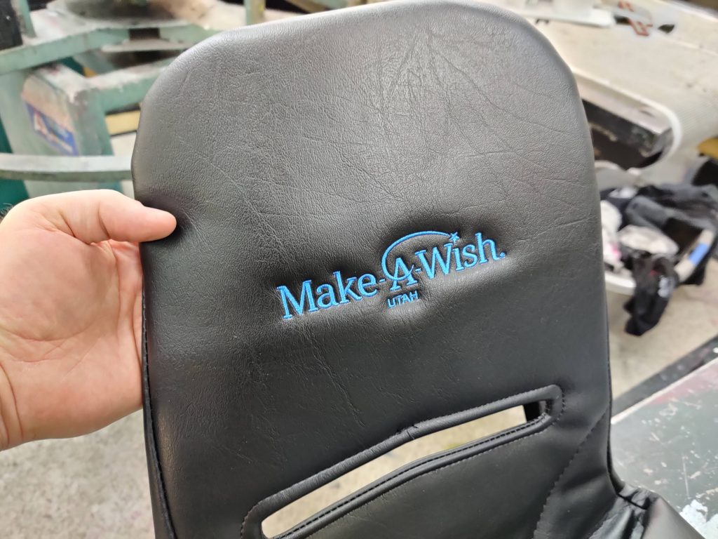 Make-a-wish logo on all-terrain wheelchair seat cover.