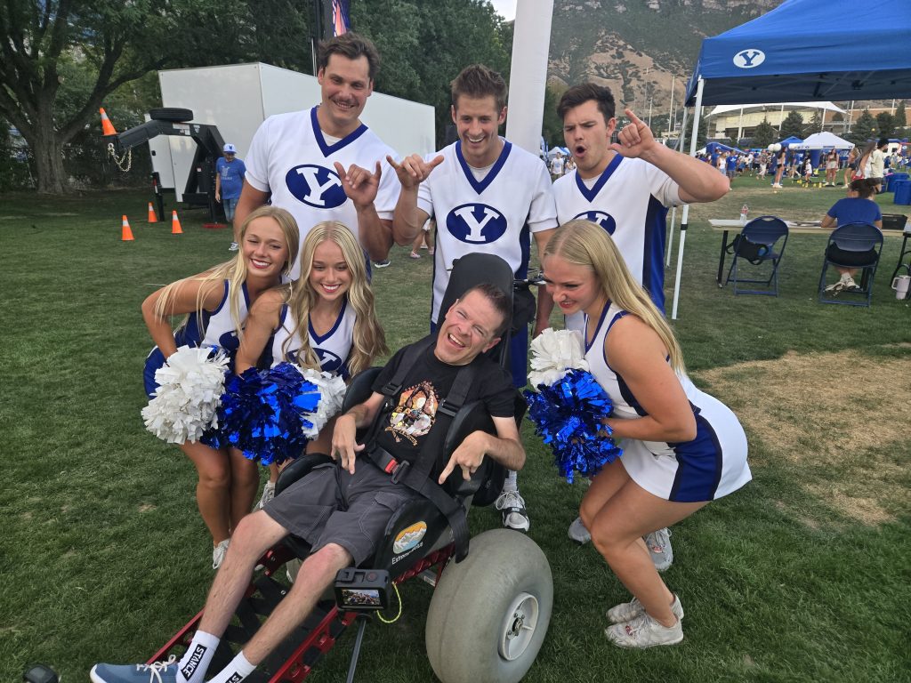  Sam poses with BYU cheerleaders in his extreme motus all terrain wheelchair.