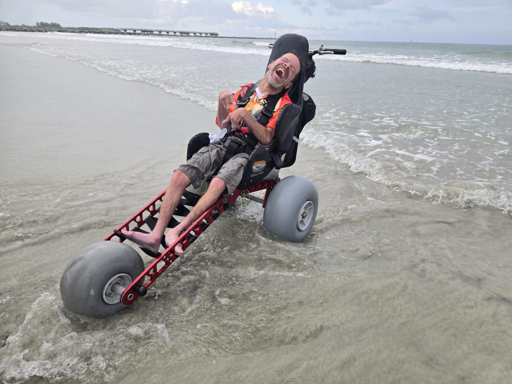 Huge smile from sam at cocoa beach in his beach wheelchair