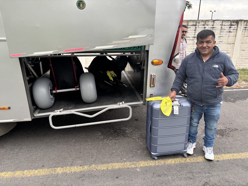 Bus driver Guillermo with Extreme Motus all-terrain wheelchairs loaded in the luggage bay of a bus bound for Shell, Ecuador