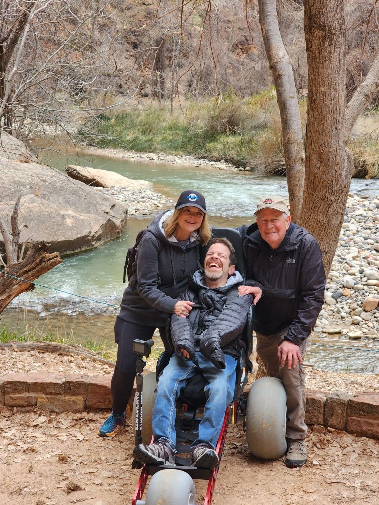 Wheelchair user demonstrating outdoor accessibility with an all-terrain wheelchair at a state park