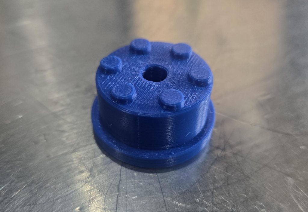 Blue 3D-printed wheelchair camera mount insert for the Extreme Motus all-terrain wheelchair